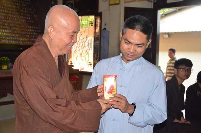 Granting lucky envelop on Tet occasion and handing in a python