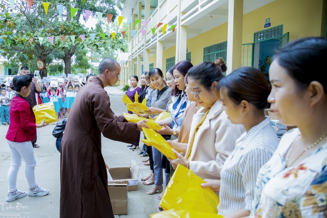 Giving gifts to pupils on occasion preparing Lunar New Year
