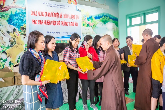 Giving gifts to pupils on occasion preparing Lunar New Year