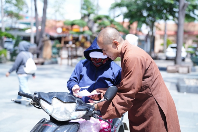 Giving gifts for difficult households during the Ullambana season in Hoc Mon commune in the temple charity activities